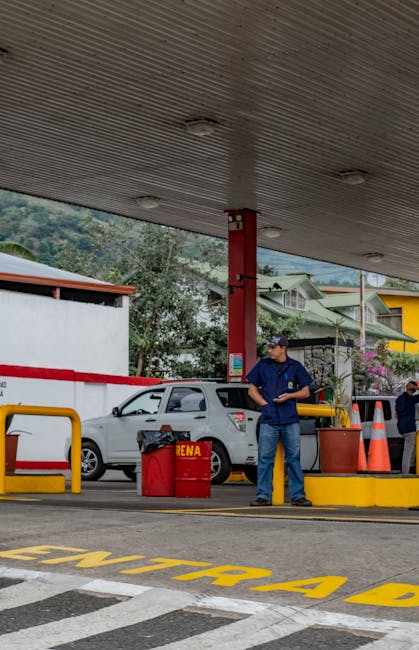 A man standing near fuel pumps at a gas station in Costa Rica, illustrating daily life.